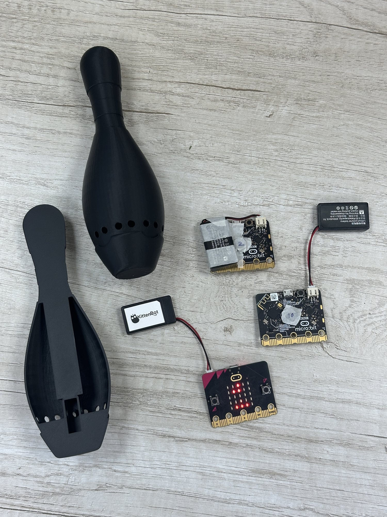 Exploded bowling pin enclosure with microcontrollers, speaker modules, and battery