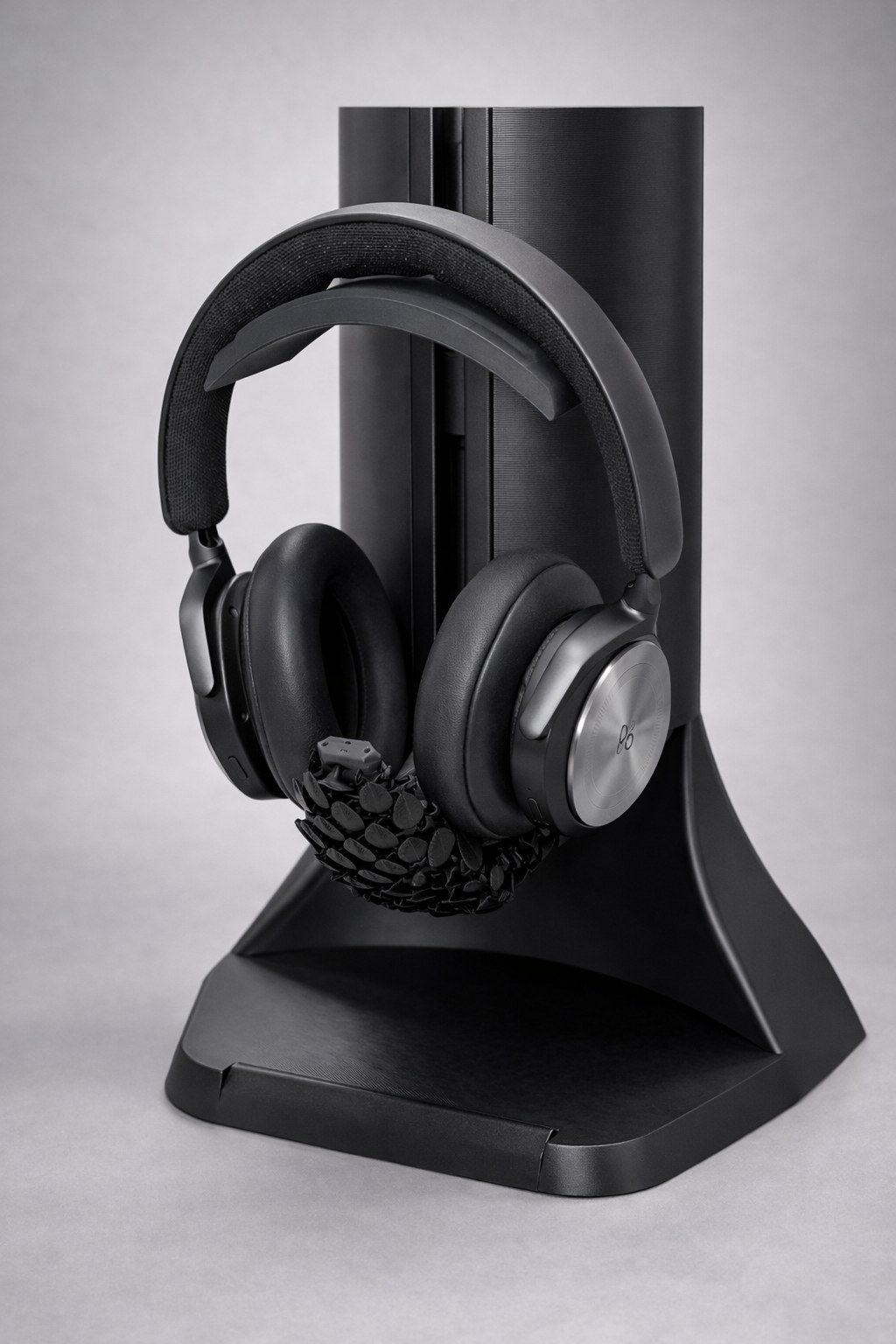 Pangolin headphone stand with its articulated tail curled around the headphones