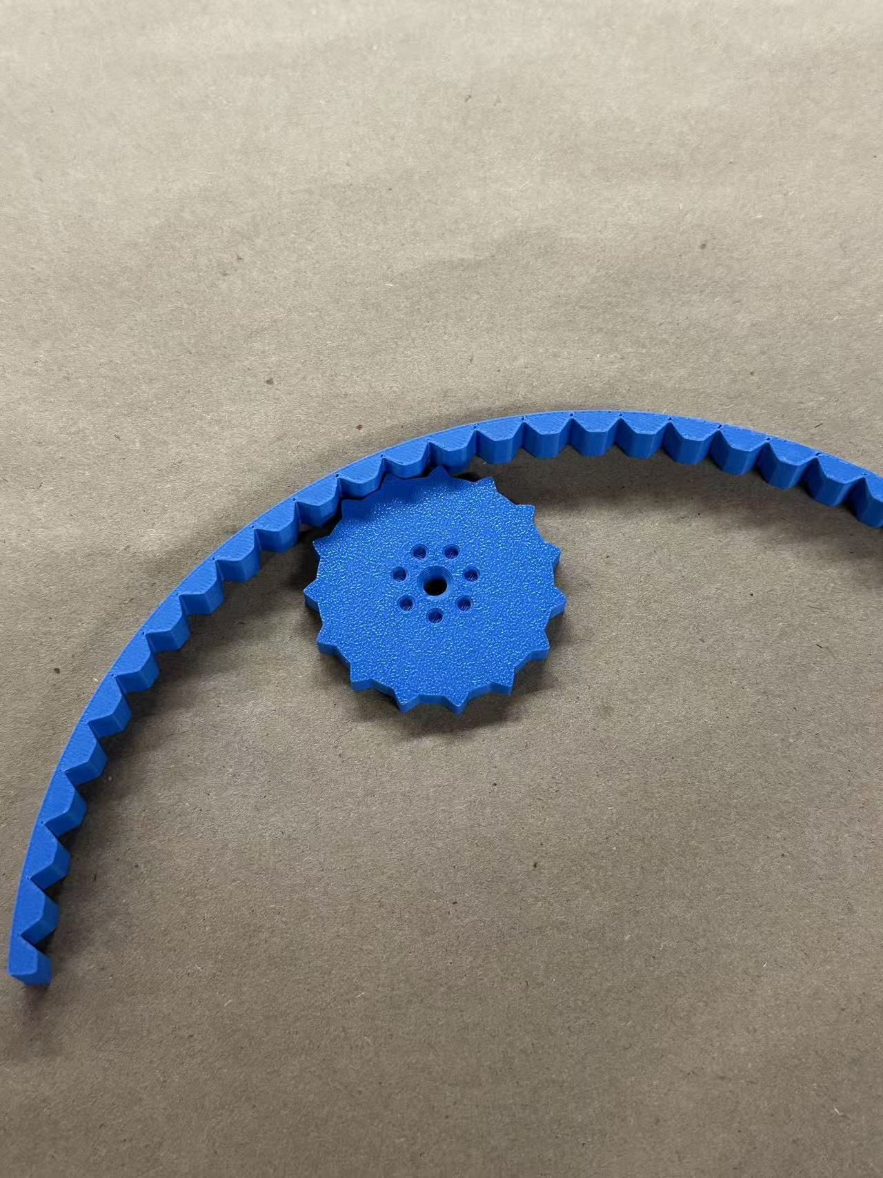 Blue 3D-printed gear and flexible toothed strip used in mechanism exploration